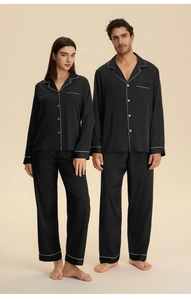 Matching black satin pajama set for couples with white piping and long sleeve button-down