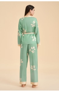 Rear view of light green satin pajamas with white leaf print and elegant cream waistband