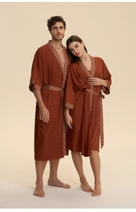 Close-up of rust red satin robe with vintage ethnic patterns on the V-neck and cuffs