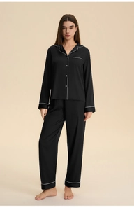 Women's black satin pajamas set featuring long sleeves and elegant white piping detail