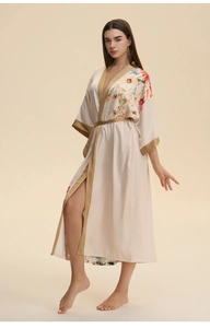 Détail de l'élégant imprimé floral et de la bordure en satin doré sur le peignoir femme
