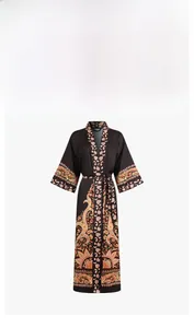 Detail view of ethnic floral print cuffs and hem on a long-sleeved satin kimono robe