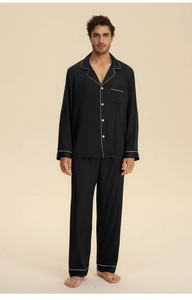 Detail of men's black satin pajama set with contrast white piping and silk texture