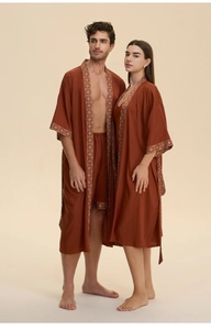 Detail view of brick red satin pajama set with retro geometric trim on a studio model