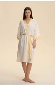 Close-up of white satin robe featuring yellow geometric floral patterns on lapels and sleeves