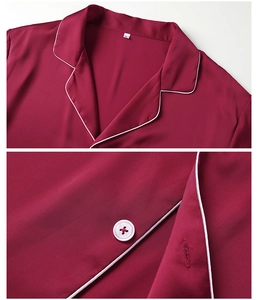 Close-up of wine red satin pajama lapel with white contrast piping and button detail
