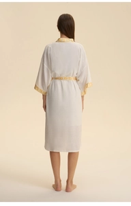 Detail of white satin robe featuring yellow geometric patterns on collar and waist tie