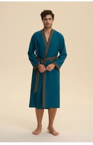 Detail of teal long-sleeved bathrobe featuring orange geometric patterns on cuffs and collar