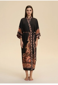 Detail of floral paisley print on long black silk-like kimono robe with V-neckline