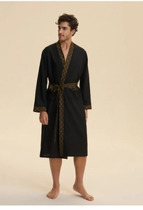 Detail of black men's robe featuring golden vintage patterns on cuffs and belt