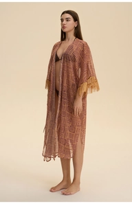 Detail of printed chiffon beach cover-up featuring geometric patterns and fringed cuffs