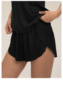 Détail d'un short de pyjama en satin noir avec fente latérale et texture soyeuse