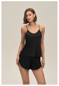 Détail de l'ensemble de pyjama en satin noir montrant la texture douce de la soie