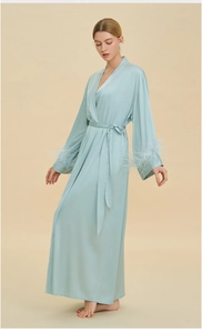 Detailed view of light blue satin bathrobe with luxury feather cuffs and silk texture