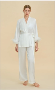 Close-up detail of luxurious white satin pajama sleeve with fluffy feather trim