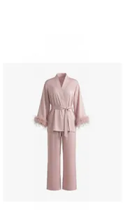 Macro shot of satin sleepwear set showing detachable feather cuffs and fabric texture