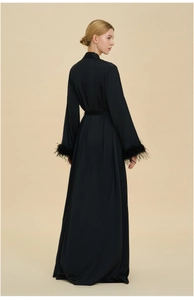 Détail du peignoir en satin noir avec poignets en plumes et ceinture à la taille