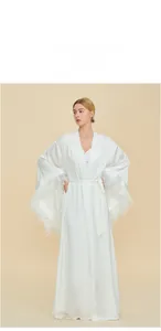 Detail view of white silk morning robe with luxurious feather trim on sleeve cuffs