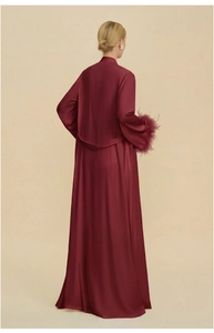 Détail d'un peignoir en satin bordeaux avec poignets en plumes vus de l'arrière