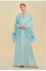 Close-up of luxurious light blue silk robe featuring elegant detachable feather trim on cuffs