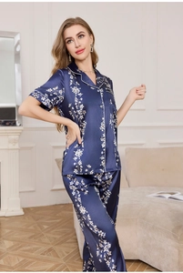 Detail view of navy blue silk pajama set with floral print and white piping accents