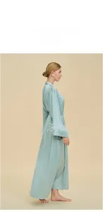 Detail of light blue satin robe featuring luxurious ostrich feather trim on the cuffs