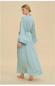 Detail of luxurious mint satin robe featuring elegant detachable feather trim on the sleeves