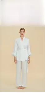 Luxurious white satin pajama set featuring elegant feather trim on sleeves and belted waist