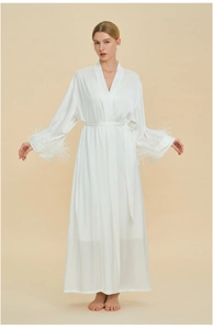 Close-up of elegant white silk robe featuring luxurious ostrich feather trim on cuffs
