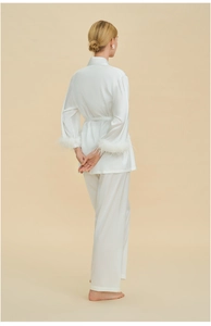 Rear view of white satin pajamas featuring elegant detachable feather cuffs on sleeves