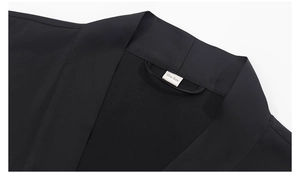 Vue détaillée du col du peignoir noir avec une étiquette tissée indiquant la taille unique