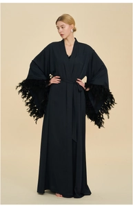 Detail of elegant black long robe with luxury feather trim on wide flared sleeves