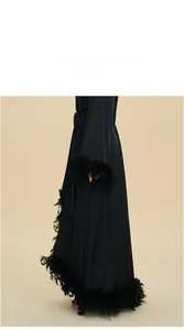 Detail view of luxurious black satin robe featuring elegant feather trim and silk texture