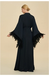 Elegant long black satin robe featuring luxurious feather trim on wide bell sleeves