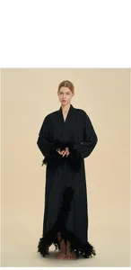 Detailed view of luxury black silk robe featuring elegant feather trim on cuffs and hem