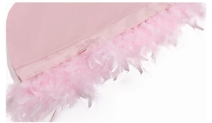 Detail of elegant pink satin nightdress sleeve featuring luxurious ostrich feather trim