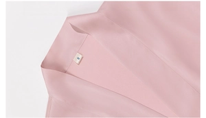 Detail of pink satin pajama top with V-neckline and high-quality stitching texture