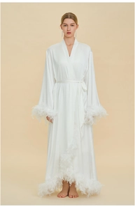 Detailed view of white silk robe featuring elegant ostrich feather trim on sleeves and hem
