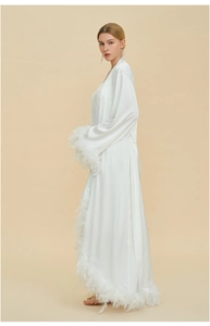 Luxurious white satin robe featuring elegant feather trim on long sleeves and hemline