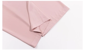 Detailed close-up of smooth pink fabric featuring precision stitching on the hemline