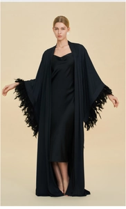 Detailed view of the luxurious black sleeve cuffs featuring dense and dynamic feather trim