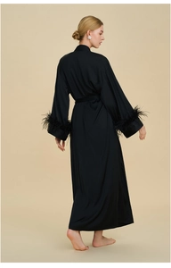 Close-up of luxury black satin robe featuring elegant feather trim on the sleeves