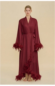 Long-sleeved burgundy silk robe featuring elegant feather trim on cuffs and hemline