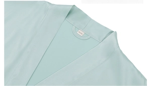 Macro detail of the mint green satin robe collar with One Size label and fine stitching