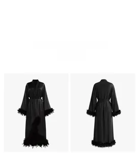 Detail view of black silk satin robe with luxury feather trim on sleeves and hemline