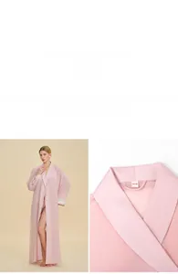 Dettaglio dell'accappatoio in chiffon rosa con polsini in pizzo e finiture in raso