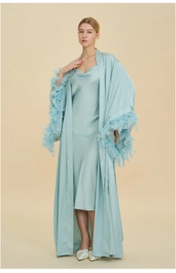 Detailed view of mint green silk robe featuring elegant feather trim on the sleeve cuffs