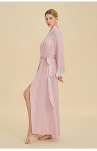 Dettaglio della vestaglia in chiffon rosa chiaro con pizzo bianco e cintura