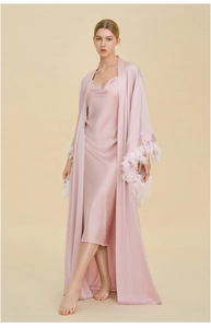 Close-up of elegant pink satin robe set featuring luxury white feather cuffs and silk dress
