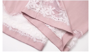 Dettaglio del tessuto in chiffon rosa con delicato bordo in pizzo floreale bianco